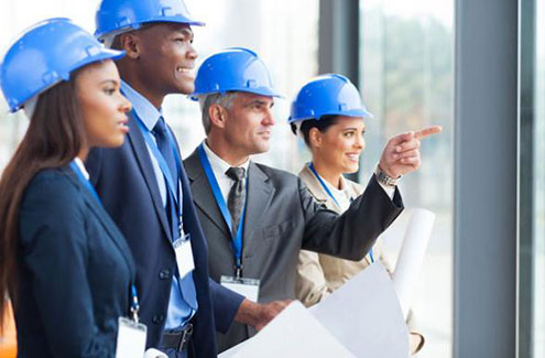 group of managers in hard hats viewing a construction site