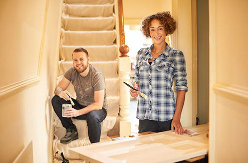 two people doing home renovations by a stairwell