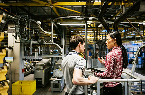 two professionals talking in a manufacturing facility