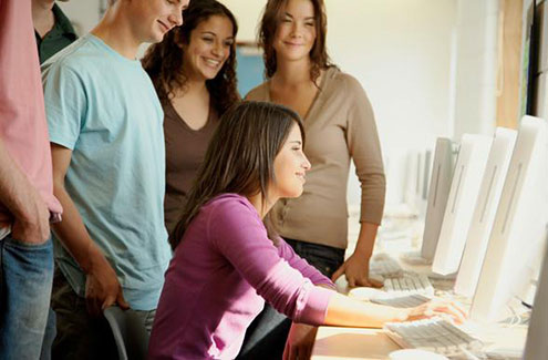 Students gathered around one computer screen