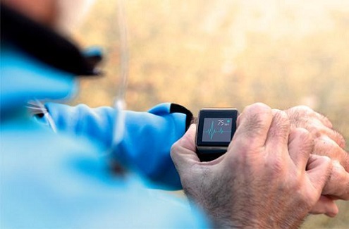 person outdoors looking at a digital watch